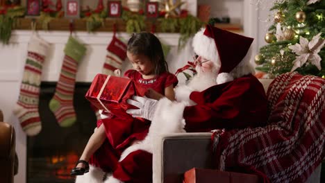 Santa-Claus-gibt-anwesend,-um-junge-Mädchen