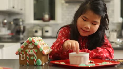 Young-girl-decorating-gingerbread-house