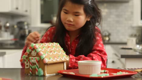 Young-girl-decorating-gingerbread-house