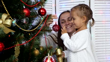 Chicas-felizes,-madre-e-hija-decorando-un-árbol-de-Navidad-en-casa.