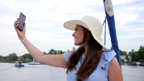 nettes-Mädchen-machen-Selfie-auf-Yacht,-android-in-Hand-Frauen,-Urlaubsbilder,-Frau-tun-Bilder-auf-Ihrem-Handy-unter-freiem-Himmel