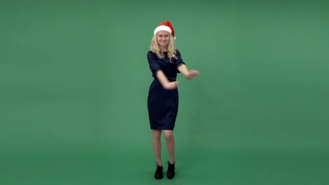 Young-blonde-woman-in-a-santa's-cap-dancing-and-hanging-out,-chroma-key-green-screen