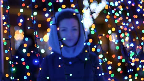 Portrait-of-pretty-girl-shrouded-bright-christmas-lights