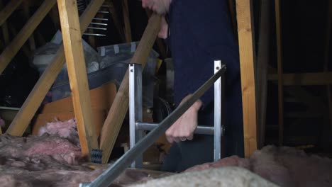 Adult-male-climbing-an-attic-ladder-and-entering-the-attic-looking-for-something-stored-away