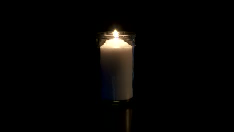 Slow-motion-macro-footage-of-a-white-candle-on-a-dark-background