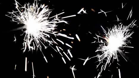 Close-up-burning-of-Christmas-sparklers.-Fireworks-lit-on-black-background.