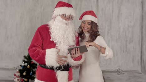Loughing-Santa-and-beautiful-woman-use-tablet