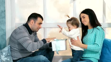 Schöne-Weihnachten-glückliche-Familie-mit-kleinen-Mädchen-in-gestrickten-Pullover-sitzt-auf-der-Fensterbank