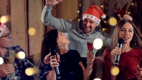 Group-of-joyfull-friends-singing-karaoke-having-fun-at-Christmas-party.-4K.