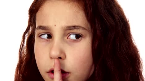 A-little-girl-brings-a-finger-to-her-mouth-and-asks-for-silence