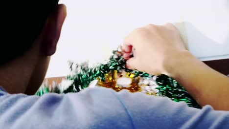 4K-Hands-of-person-hanging-Christmas-decoration-on-the-wall.-Vintage-toned-footage.