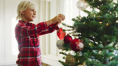 Kleiner-Junge-dekorieren-Weihnachtsbaum