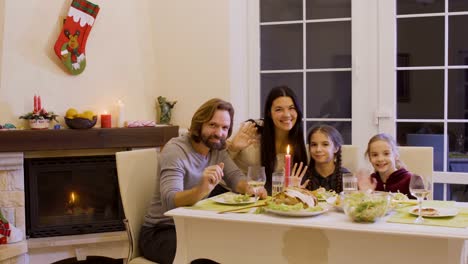 Familia-feliz-celebra-la-Navidad-en-la-mesa-festiva