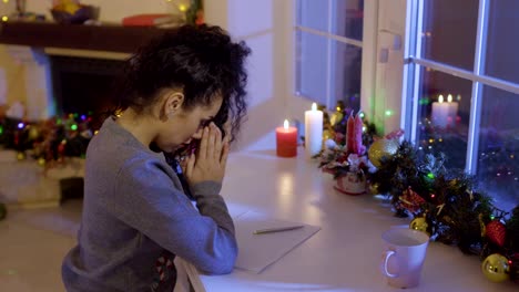 Schönes-Mädchen-betet-vor-dem-Schreiben-einer-Wunschliste-auf-dem-Weihnachtsmarkt