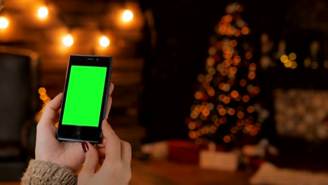 Woman-looking-at-smartphone-with-green-screen