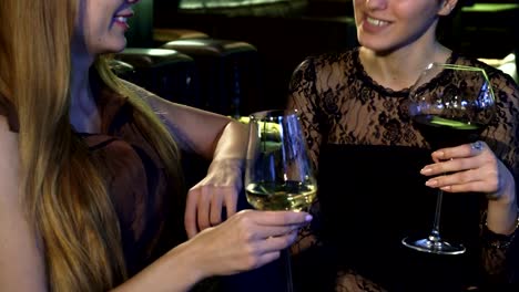 Beschnitten,-Aufnahme-von-zwei-Jungen-glücklich-Frauen-Lächeln-im-Gespräch-bei-einem-Glas-Wein-an-der-bar