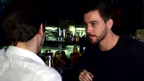 Young-male-friends-talking-while-having-drinks-together-at-the-bar