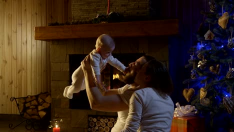 Young-happy-family-with-infant-celebrating-Christmas