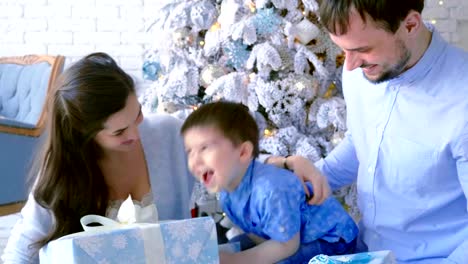 Glückliche-Familie,-Mutter-Vater-Sohn,-stapeln-sich-Kartons-mit-Geschenken.-Weihnachten-Hintergrund.