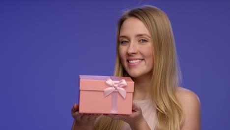 Portrait-of-a-Woman-holding-a-pink-Gift-Box-in-her-hands-on-Bluescreen