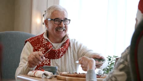 Senior-hombre-sirviendo-pastel-de-Navidad-para-la-esposa-en-la-cena-en-restaurante