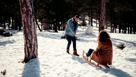 Novio-novia-tirando-trineos-en-nieve-Parque-forestal