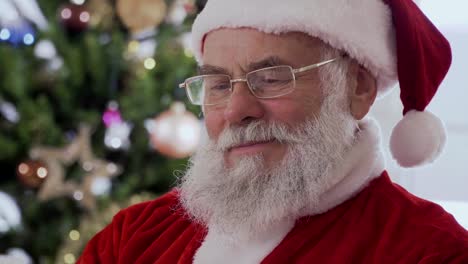 Santa-Claus-sentado-y-riéndose-mientras-leía-un-libro-divertido