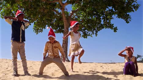 Niños-con-sombreros-de-Santa-salto-en-arena