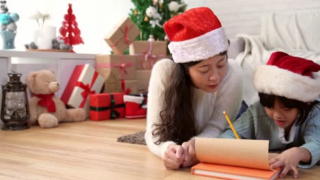 small-child-writes-the-letter-with-her-mother