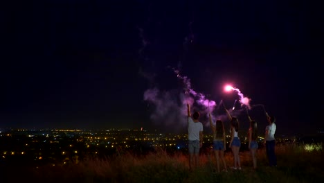 Las-cinco-personas-están-paradas-con-palos-de-fuego-sobre-un-fondo-de-ciudad.-noche