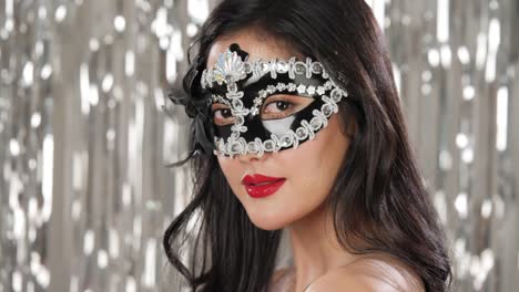 Sexy-Frau-mit-Maskerade-Maske-flirten-Party-über-Silber-Glitzer-Hintergrund,-Slow-motion