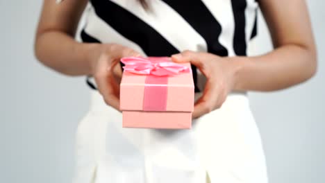 Frau-mit-einem-rosa-Geschenkbox-in-einer-Geste-des-Gebens.