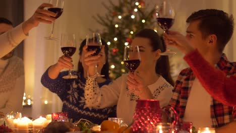 amigos-felices-bebiendo-vino-tinto-en-Navidad