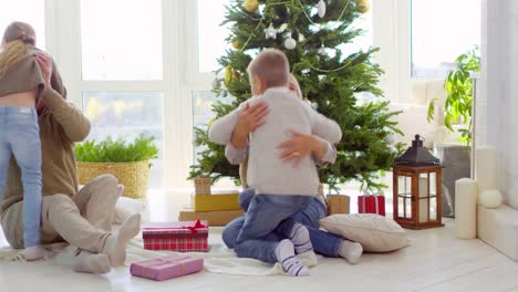 Kinder-umarmen-Großeltern-am-Weihnachtsmorgen