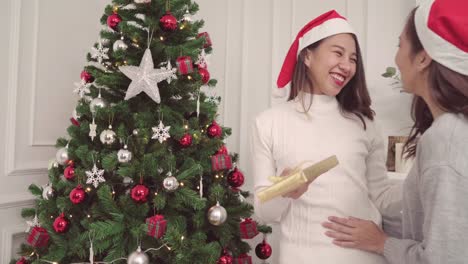 Gruppe-von-fröhlich-glücklich-junge-asiatische-Frauen-Weihnachten-Geschenke-miteinander-in-ihrem-Wohnzimmer-zu-Hause-in-Christmas-Festival.-Lifestyle-Frauen-feiern-Weihnachten-und-Neujahr-Konzept.