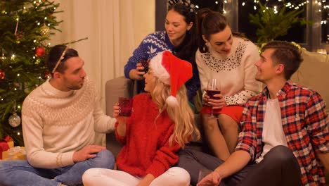 friends-celebrating-christmas-and-drinking-red-wine-at-home