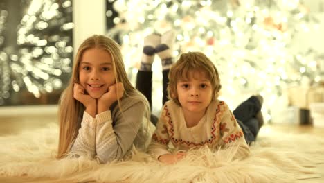 The-cute-boy-and-a-girl-laying-on-the-floor-near-the-christmas-tree