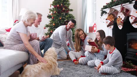 Drei-Generationen-Familie-tragenden-Pyjamas-Lounge-im-Hause-Öffnung-Geschenke-am-ersten-Weihnachtstag