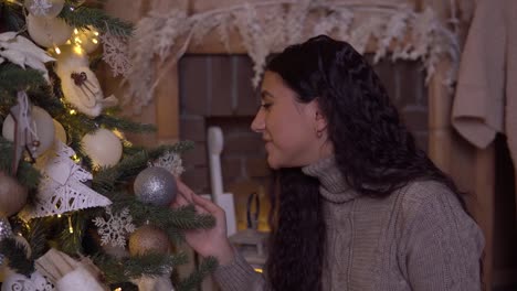 Una-niña-adorna-un-árbol-de-Navidad-con-una-hermosa-bola-de-tener-buen-humor