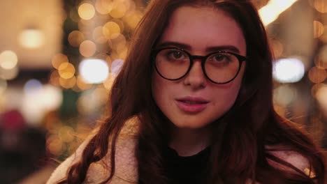 Girl-have-fun-near-Christmas-tree-and-smile-to-camera