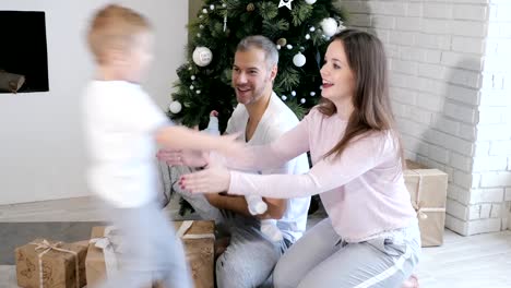 Familia-de-diversión-cerca-del-árbol-de-Navidad-y-regalos