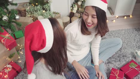 Lesbian-Asian-couple-packing-and-wrapping-Christmas-present-decorate-her-living-room-at-home-in-Christmas-Festival.-Lifestyle-lgbt-women-happy-celebrate-Christmas-and-New-year-concept.