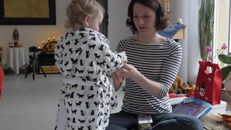 Mother-Dressing-Toddler-in-Bathrobe-at-Christmas