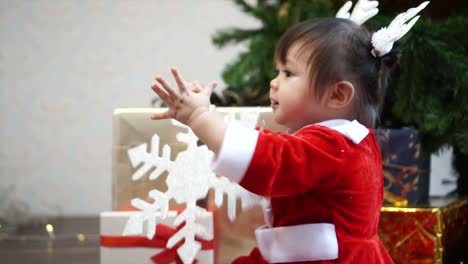 Niedliche-1-Jahr-alt-Baby-Mädchen-tragen-Rentier-Haarreif-mit-Christbaumkugel-mit-Weihnachtsbaum-im-Hintergrund-zu-spielen.-Frohe-Weihnachten-und-schöne-Feiertage!