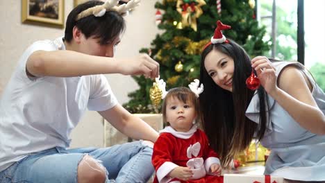 Glückliche-Familie-Mutter-Vater-und-Kind-Tochter-mit-Weihnachtsbaum-zu-Hause.-Closeup-Zeitlupe-Porträt-des-liebenden-Familie,-Frohe-Weihnachten-und-schöne-Feiertage!