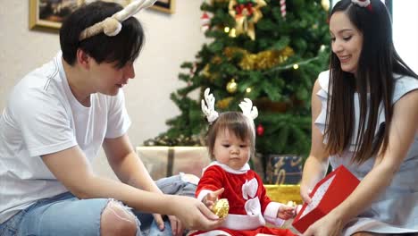 Glückliche-Familie-Mutter-Vater-und-Kind-Tochter-mit-Weihnachtsbaum-zu-Hause.-Closeup-Zeitlupe-Porträt-des-liebenden-Familie,-Frohe-Weihnachten-und-schöne-Feiertage!