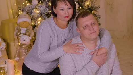 Glückliches-Paar-Mann-und-Frau-umarmt-und-posiert-auf-hellen-Neujahrsfeier