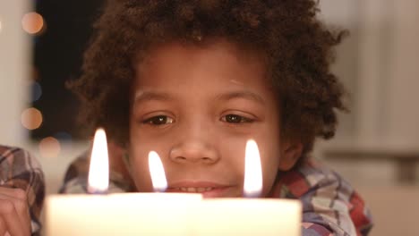 Smiling-boy-looks-at-candle.