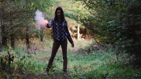 Beautiful-girl-in-a-forest-pulls-a-pink-smoke-grenade-and-waves-it-around,-slow-motion