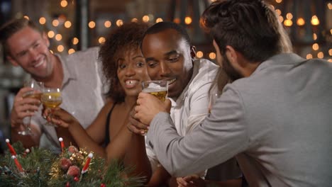 Freunde-machen-einen-Toast-auf-einer-Weihnachtsfeier-in-einer-bar